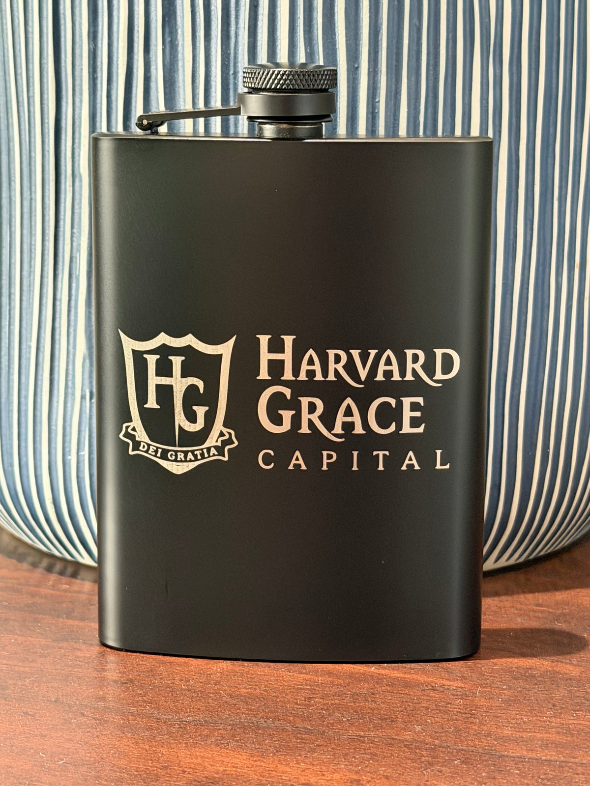 Matte black 8 oz hip flask laser engraved with the Harvard Grace Capital business logo
