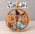 Round wooden marching band shaker ornament with a uniform, trumpet, and music notes, beads in school colors, and the name, school, and year