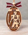 Layered wood football ornament with a football player, jersey number, last name, team name, and year, tied with a football ribbon