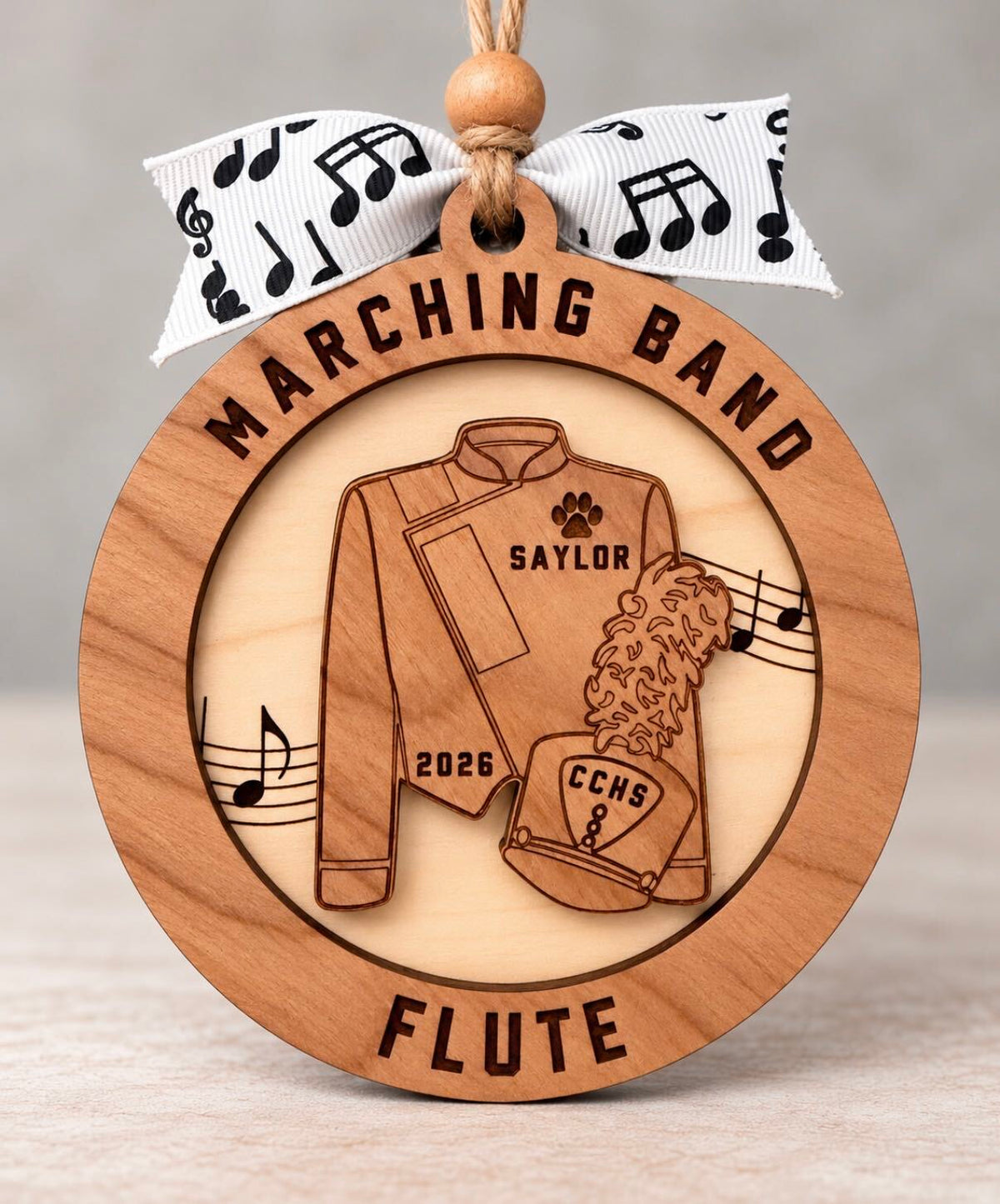 Round layered wood marching band ornament with a band uniform, name, school, instrument, and year, tied with a music note ribbon