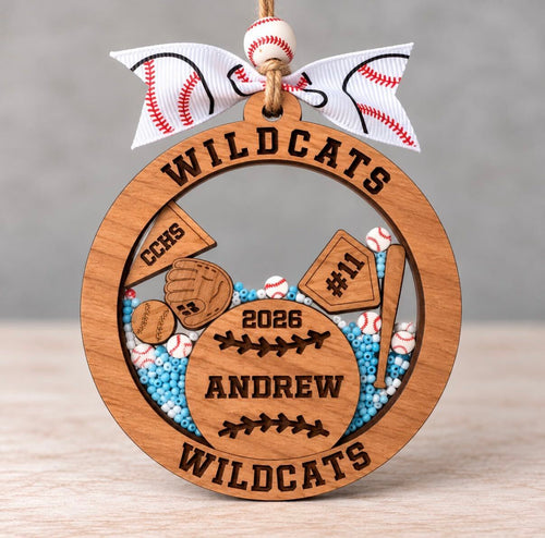 Round wooden baseball shaker ornament with a glove, bat, home plate, and pennant, filled with blue and white beads and mini baseballs, personalized with Andrew, number 11, Wildcats, and 2026