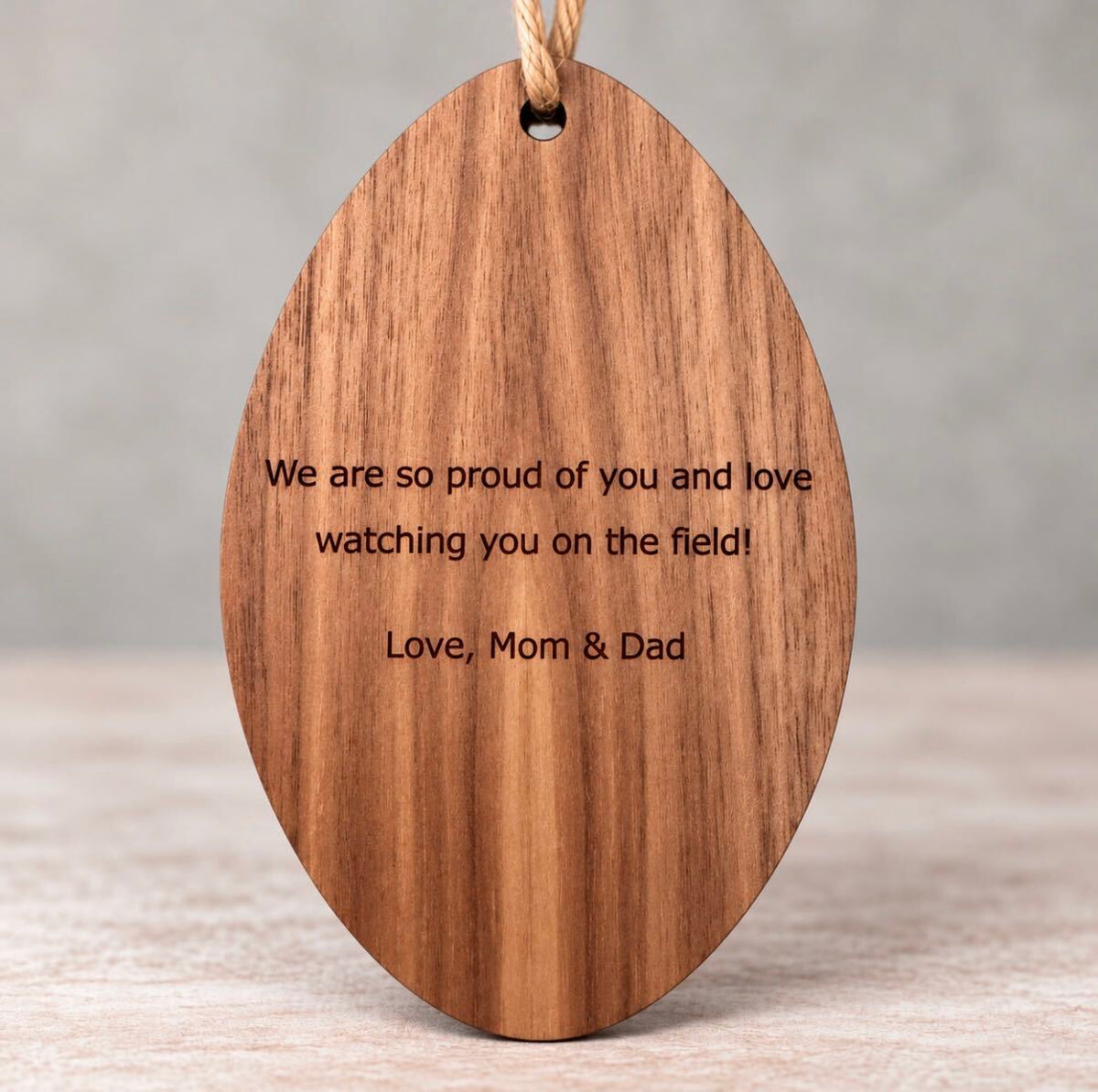Back of a wooden ornament laser engraved with a personal message from Mom and Dad