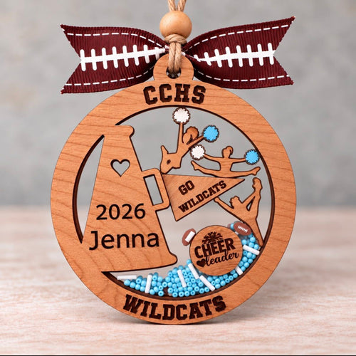 Round wooden cheerleader shaker ornament with a megaphone and pom poms, beads in school colors, and her name, school, team, and year